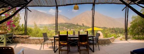 a table and chairs with a view of mountains at Las Cabañas de Tarii in Cieneguilla