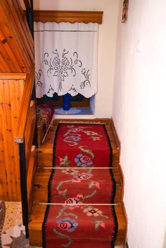 a stairway with a red carpet and a window at Guest House Salaria in Gjirokastër