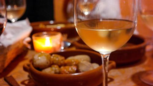 a glass of wine next to a bowl of food and a candle at Redondo de Guayedra in Guayedra
