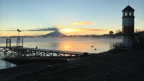 a dock with a light house and a lighthouse at Cabañas Puerto Chalhuaco in Puerto Varas