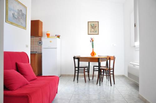 a living room with a red couch and a table at Sa Teria Village - Appartamenti - in Tertenìa