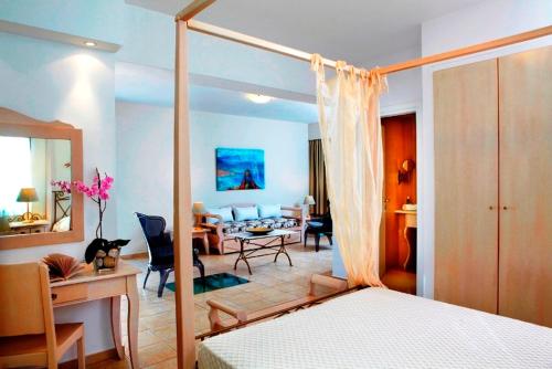 1 dormitorio con 1 cama y sala de estar en Mitos Suites en Agios Prokopios