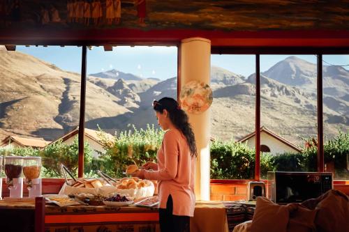 a woman standing in front of a table with food at Casona Plaza Ecolodge Colca in Yanque