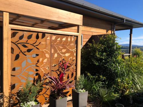 a fence with plants in pots in a garden at Callemondah Studio with stunning views, in Bangalow and Byron Hinterland in Bangalow
