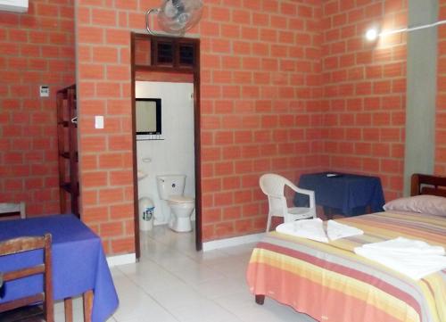 a room with two beds and a bathroom with a toilet at Hotel Ambaibo in Rurrenabaque