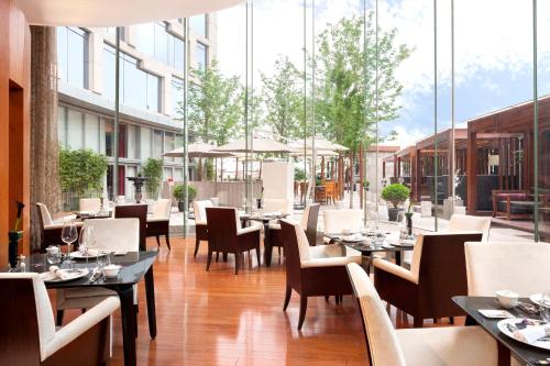 a restaurant with tables and chairs and windows at The Langham, Shanghai, Xintiandi in Shanghai