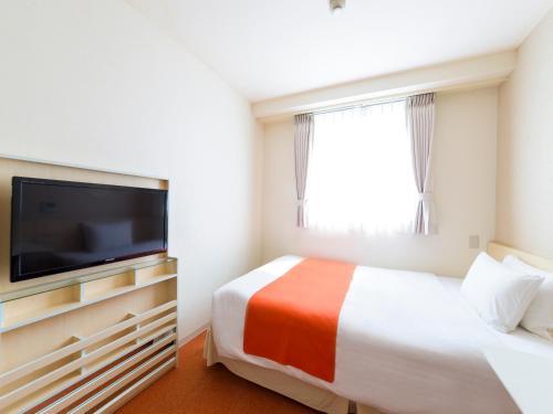 a hotel room with a bed and a flat screen tv at Hotel Abest Naha Kokusai Street in Naha