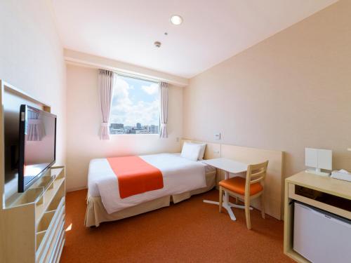 a hotel room with a bed and a television at Hotel Abest Naha Kokusaidori in Naha