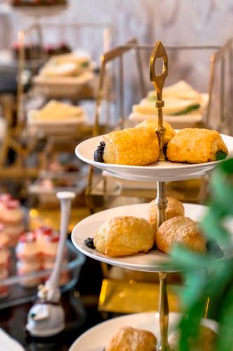 a three tiered plate of pastries on a table at Savero Hotel Depok in Depok
