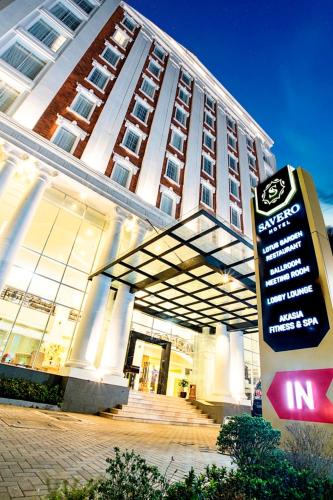 a large building with a sign in front of it at Savero Hotel Depok in Depok
