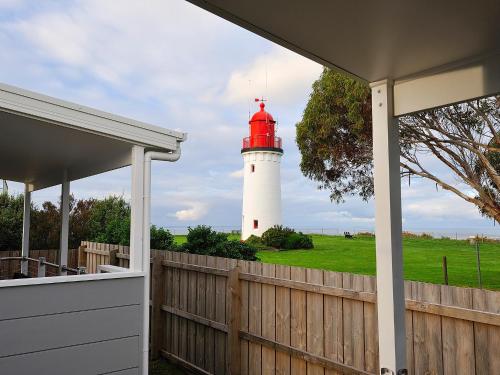 a lighthouse with a red and white lighthouse at NRMA Portland Bay Holiday Park in Portland