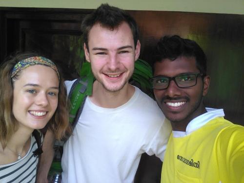 two men and a woman posing for a picture at Munroe Coconut Homestay in Munroe Island