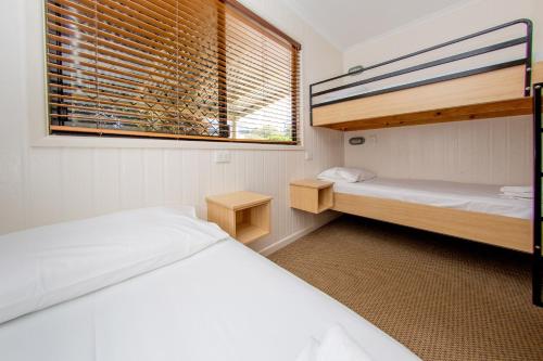a bedroom with two bunk beds and a window at BIG4 Park Beach Holiday Park in Coffs Harbour