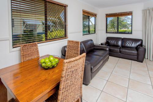 a living room with a wooden table and a couch at BIG4 Park Beach Holiday Park in Coffs Harbour