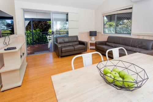a living room with a couch and a table at BIG4 Park Beach Holiday Park in Coffs Harbour