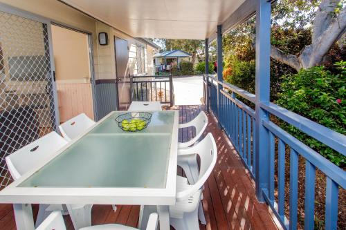 a table and chairs on the balcony of a house at BIG4 Park Beach Holiday Park in Coffs Harbour