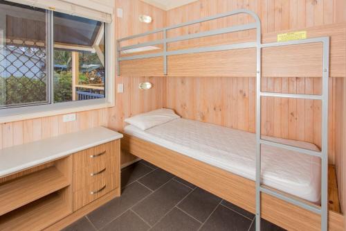 a small room with a bunk bed and a window at BIG4 Park Beach Holiday Park in Coffs Harbour