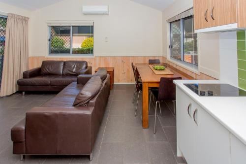 a living room with a couch and a table at BIG4 Park Beach Holiday Park in Coffs Harbour