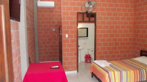 a bedroom with a bed and a brick wall at Hotel Ambaibo in Rurrenabaque
