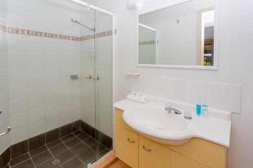 a bathroom with a sink and a glass shower at BIG4 Park Beach Holiday Park in Coffs Harbour