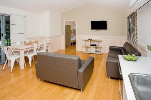 a living room with a couch and a table at BIG4 Park Beach Holiday Park in Coffs Harbour