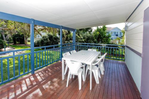 a balcony with a white table and chairs on it at BIG4 Park Beach Holiday Park in Coffs Harbour