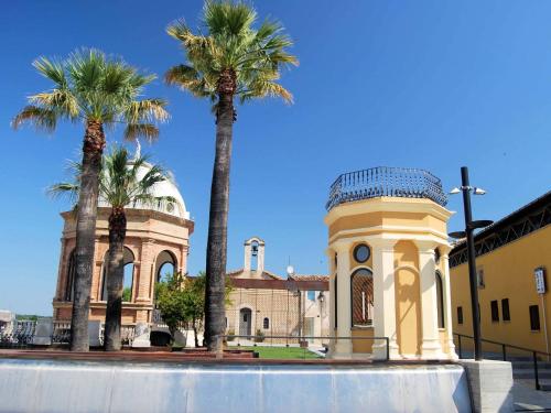 a building with palm trees in front of it at Hostal Fabrellas in Caldes de Malavella