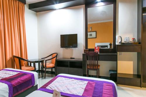 a room with two beds and a table and a mirror at HOTEL SAHARA SDN BHD in Rawang