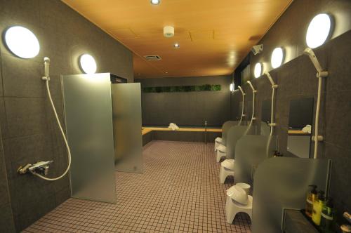 a bathroom with a row of urinals and a row of toilets at Grand Park Hotel The Luxueux Minami Kashiwa in Kashiwa
