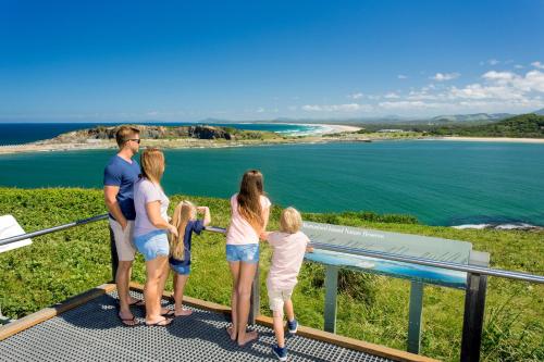 a family looking at the ocean from a viewing platform at BIG4 Park Beach Holiday Park in Coffs Harbour