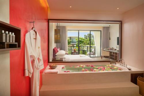 a bathroom with a bath tub with a bedroom at Metta Residence & Spa in Siem Reap