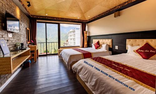 a hotel room with two beds and a large window at Phuong Nam Hotel in Sa Pa
