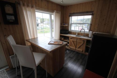 a kitchen with a table and chairs and a sink at Tadou-Shack in Tadoussac