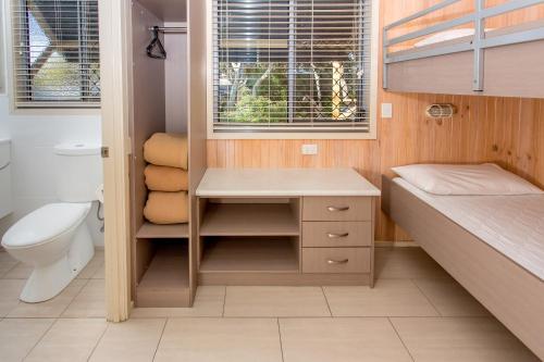 a small bathroom with a bed and a sink at BIG4 Sawtell Beach Holiday Park in Sawtell
