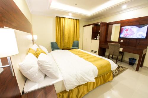 Habitación de hotel con cama, escritorio y TV. en Farha International Residential Units, en Yeda
