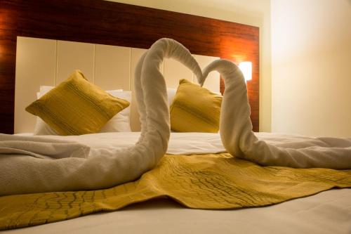 two swans are sitting on top of a bed at ضيافة بلس شقق مخدومة أقتصادية Dyafah plus 1 in Jeddah