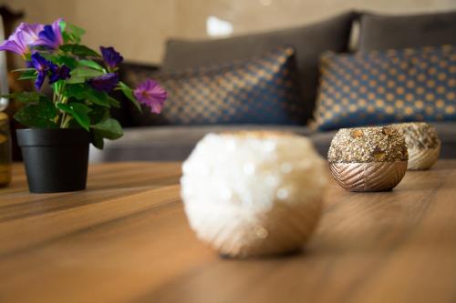 a living room with a couch and a table with bowls on it at ضيافة بلس شقق مخدومة أقتصادية Dyafah plus 1 in Jeddah