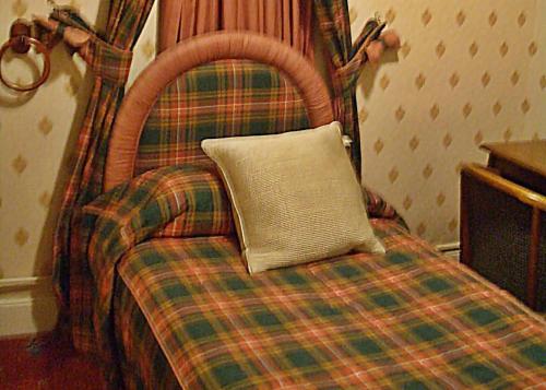 a bed with a pillow on top of it at Atholl Arms in Blair Atholl