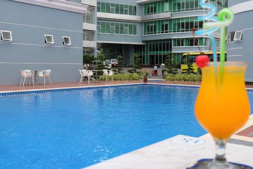 a drink sitting on a table next to a swimming pool at Ninh Kieu Riverside Hotel in Can Tho