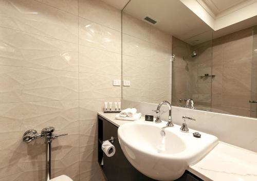 a bathroom with a sink and a shower and a tub at Burke and Wills Hotel Toowoomba in Toowoomba