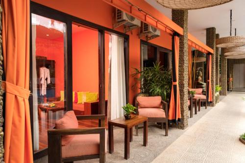 a row of chairs and tables on a building with orange walls at Golden Temple Hotel in Siem Reap