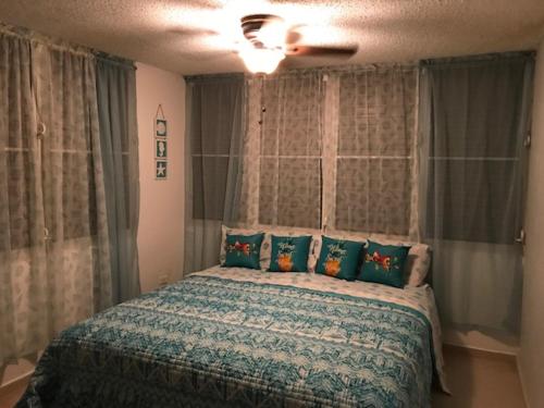 a bedroom with a large bed with pillows at Luquillo Beach Vacation in Luquillo