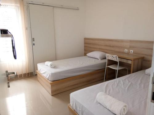 a bedroom with two beds and a chair in it at Wika Bali Beach House in Jimbaran