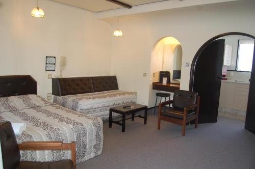 a hotel room with two beds and a desk at Alcala Motor Lodge in Dunedin