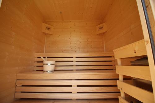 a wooden sauna with a bucket in the middle at Chalet Fügen in Fügen