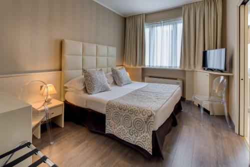 een hotelkamer met een bed en een televisie bij Best Western Hotel Nuovo in Garlate
