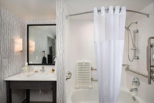 a bathroom with a sink and a shower curtain at Best Western Plus Agate Beach Inn in Newport