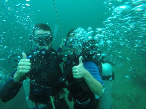 two people giving the thumbs up while diving in the water at Ecolodge el Arca Bahia Solano in Bahía Solano