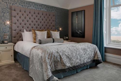 a bedroom with a large bed and a large window at Glendower Hotel BW Signature Collection in Lytham St Annes