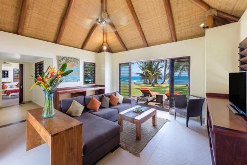 a living room with a couch and a tv at Eratap Beach Resort in Port Vila